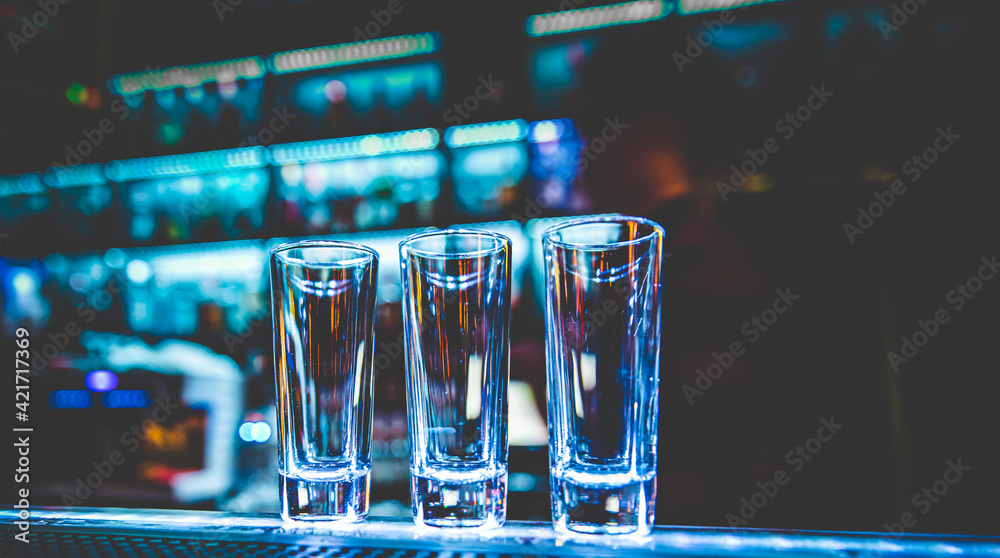 Empty glasses for shots on bar counter - obrazy, fototapety, plakaty 