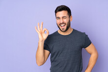 Caucasian Handsome Man Showing Ok Sign With Fingers Over Isolated Purple Background