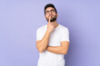 © luismolinero - Caucasian handsome man over isolated background having doubts while looking up