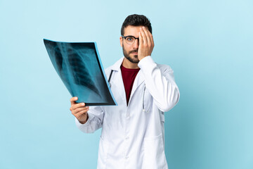 Poster - Professional traumatologist holding radiography isolated on blue background covering a eye by hand