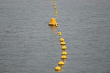 High Angle View Of Line Of Yellow Buoys  In Sea.