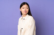 © luismolinero - Young asian woman isolated on purple background . Portrait
