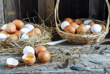Fototapeta Mapy - Fresh eggs are placed on a wooden table and fresh eggs are placed in a basket in an organic farm.