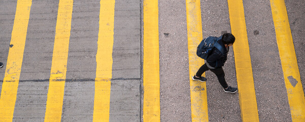 Wall Mural - High angle view of casual young man crossing street in Hong Kong　横断歩道を渡る男性 香港 ハイアングル