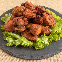 Wall Mural - Portion of fried chicken on black stone plate