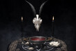 Skull of goat and black candles. Baphomet, occult and esoteric symbols. Mystical rituals and occult sciences.
