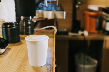 A paper coffee cup is on the counter in a coffee shop. Morning concept, coffee to go.