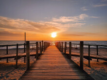 Wooden Pier On A Beach During A Beautiful Orange Sunset