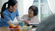 © ChayTee - Attractive young senior asian citizen couple happy sit, talk, eat soup for healthy nutrition breakfast meal on dining table at home in morning in routine lifestyle in old asia nursing in-home care.
