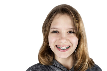 Young teen girl with braces on her teeth isolated on a white background, the girl is happy because she will correct a bad bite and her teeth will be aligned