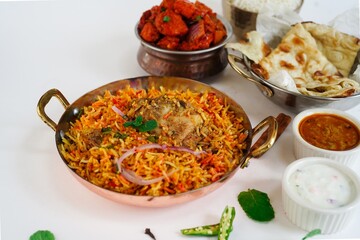 Indian Non veg meal Chicken biryani Roti Chilli chicken rice salan and Raita isolated on white