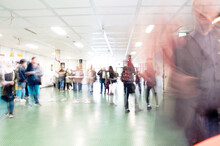 Blurred Motion Of Group Of People Walking In Corridor