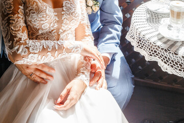 Wall Mural - the bride sits on the groom's lap, holding hands