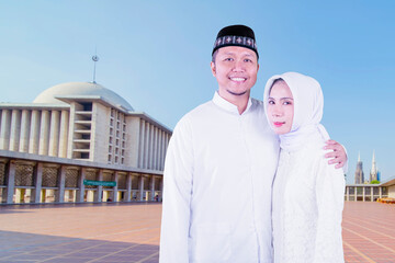 Wall Mural - Happy Muslim young couple standing in the mosque