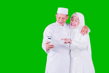 Wall Mural - Muslim elderly couple using mobile phone on studio