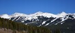 panoramic view on a sunny spring day of copper mountain ski area and snow-capped peaks from the top of vail pass, colorado