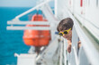 © zhukovvvlad - A child is sailing on a cruise ship, a boy in sunglasses stands on board the ship