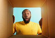© alphaspirit - Happy man receives a package from online shop order. happy and surprised expression. Blue background.