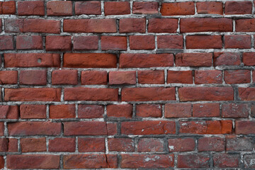  Old, broken wall of red bricks outside, close-up. Textured backdrop