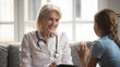© fizkes - Happy caring mature Caucasian female nurse or doctor talk with small teen girl patient at consultation in clinic. Smiling woman GP or pediatrician speak consult little kid child. Medicine concept.