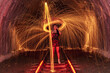 © RooM The Agency - Beautiful woman holding an umbrella standing on railway tracks surrounded by spinning wire wool