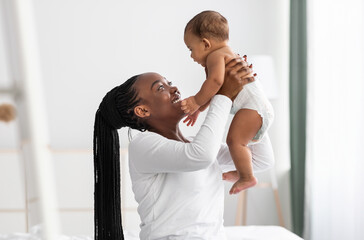 Black woman playing with her cute little infant