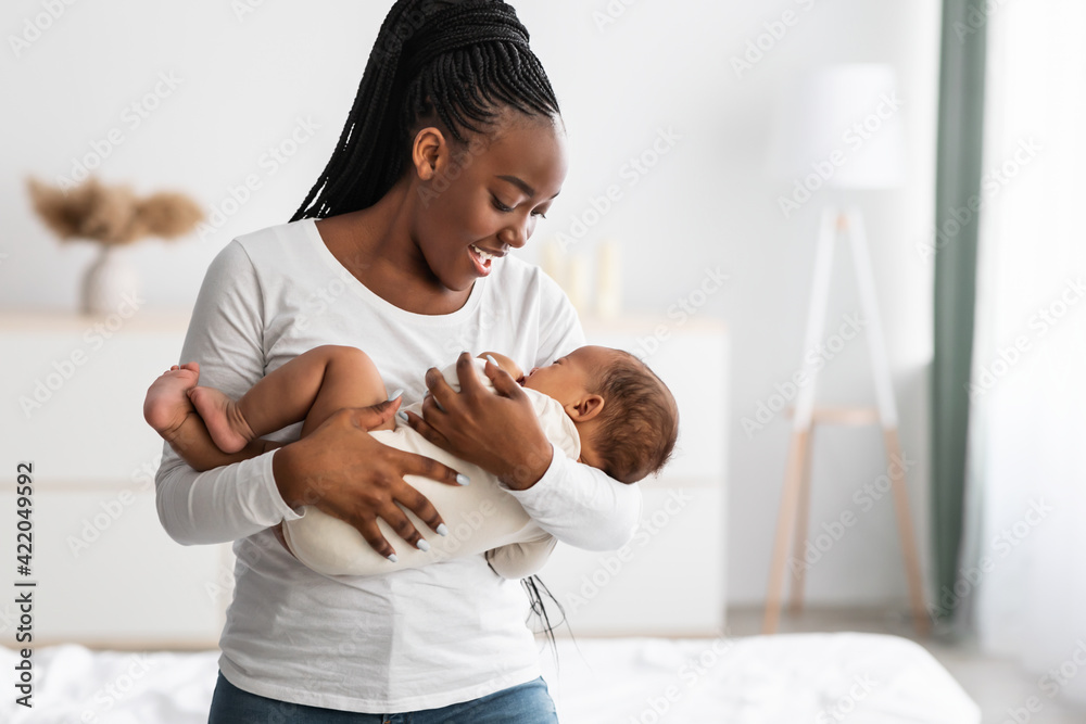 African American mother singing lullaby for infant to sleep - obrazy, fototapety, plakaty 