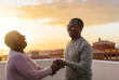 © Alessandro Biascioli - Happy Latin senior couple having romantic moment dancing on rooftop during sunset time