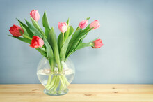 Spring Bouquet Of Red And Pink Tulips Flowers In The Glass Vase Over Wooden Table