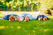 © oksix - Three little children lying on a green grass