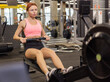 © splitov27 - Red-haired fit woman is exercising in rowing exercise machine in modern gym