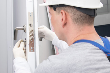 plumber, checks the correct operation, locking devices of the door lock, close-up