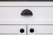 © Bruce Peter Morin - Photograph of a matte black drawer cup pull handle on a white cabinet.