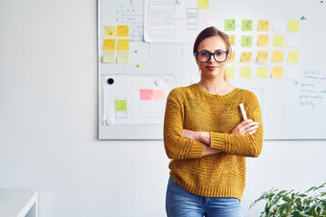 portrait of businesswoman standing in front of whiteboard in office