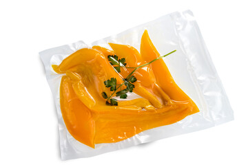 Wall Mural - yellow peppers with parsley leaves in vacuum packed sealed for sous vide cooking, isolated on white background