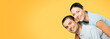 © vgstudio - Happy amazed smiling couple. Portrait of standing close embracing models in love studio concept, isolated over yellow background. Young brunette man and woman posing together. Copy space area for text