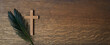 Palm sunday background. Cross and palm on wooden background.