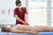 Physiotherapist in mask helping female patient