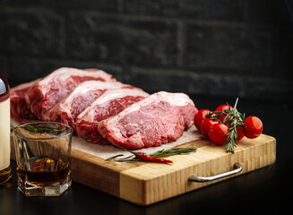 Raw veal meat tenderloins cooking preparation with a glass of whiskey 