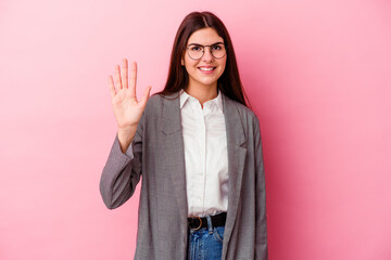 Wall Mural - Young caucasian business woman isolated on pink background smiling cheerful showing number five with fingers.