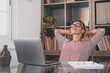 Happy satisfied caucasian woman rest at home office sit with laptop hold hands behind head, dreamy young lady relax finished work feel peace of mind look away dream think of future success concept.