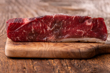 raw steak on olive wood