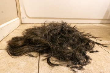 Pile of long hair on the floor after shaving head