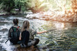 Young adult couple is fishing together on fast mountain river. Active people and sport fly fishing concept.