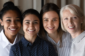 Poster - Close up headshot portrait of smiling multiethnic female colleagues coworkers look at camera pose in office. happy diverse multiracial women employees show unity. Success, leadership concept.