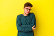 © Asier - Young caucasian man isolated on yellow background suspicious, uncertain, examining you.
