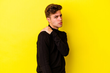 Wall Mural - Young caucasian man isolated on yellow background having a shoulder pain.