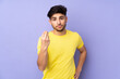 © luismolinero - Arabian handsome man over isolated background making Italian gesture