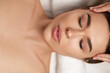 © verona_studio - Face massage. people, beauty, spa, healthy lifestyle and relaxation concept.  Close up of beautiful young woman lying with closed eyes and having face or head massage in spa
