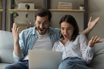 Wall Mural - Close up overjoyed young couple looking at laptop screen, reading unexpected good news, celebrating success, online lottery win, money refund, excited wife and husband received good news in email